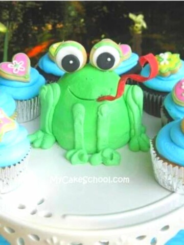 Little Frog Cake on pedestal, surrounded by cupcakes