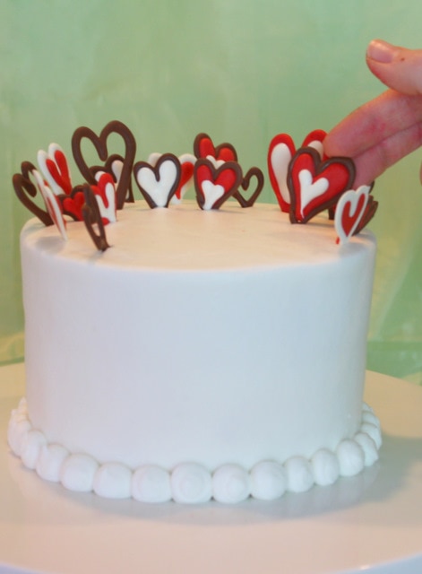 Adorable and simple Valentine's Day Cake by MyCakeSchool.com featuring chocolate hearts! Free cake decorating tutorial!