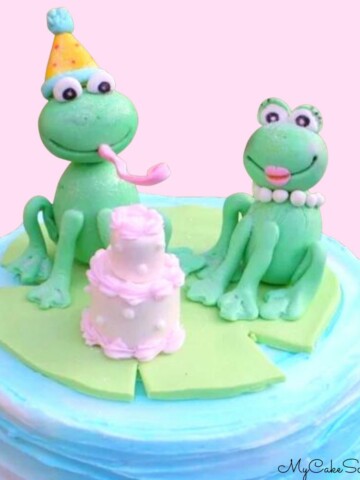 Two gum paste frogs on top of cake