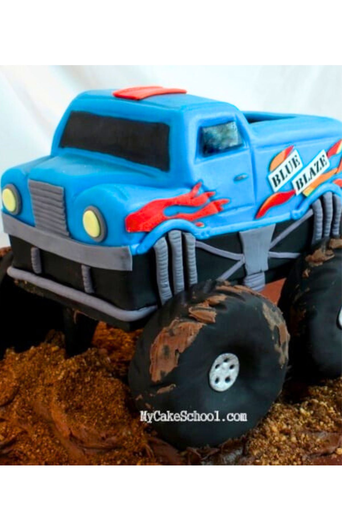 Monster Truck Cake, covered in blue fondant with red flames on the side.