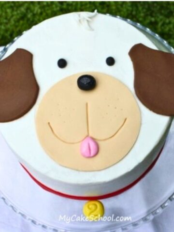 Easy Puppy Cake on a glass pedestal. Puppy face on top of a round cake.