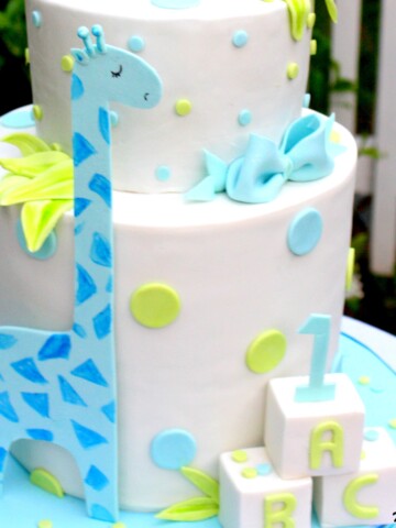 Learn how to make a double barrel cake with sweet giraffes in this MyCakeSchool.com video tutorial! Perfect for young birthdays and baby showers! MyCakeSchool.com.