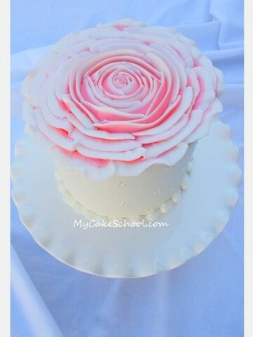 Learn to pipe an huge, elegant rose over the top of your cake in this My Cake School piping tutorial!