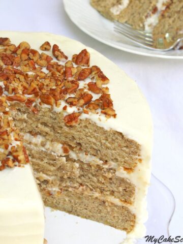 Sliced Banana Cake with Cream Cheese Frosting, on a glass pedestal.