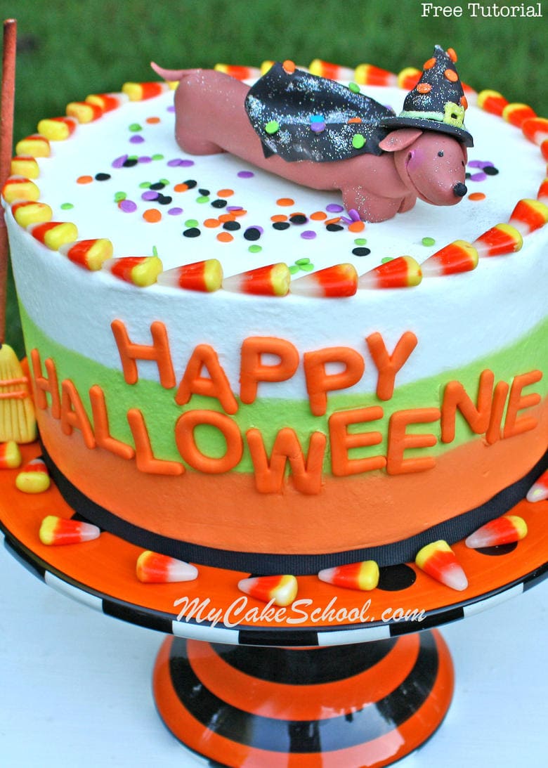 Learn to make this CUTE "Happy Halloweenie" themed Halloween cake in My Cake School's free video tutorial! Learn to make tri-colored buttercream as well as an adorable "weenie dog" witch cake topper!