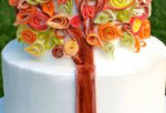 Autumn Quilling Cake on a cake plate-- a fondant tree trunk with fondant quilled colorful leaves.