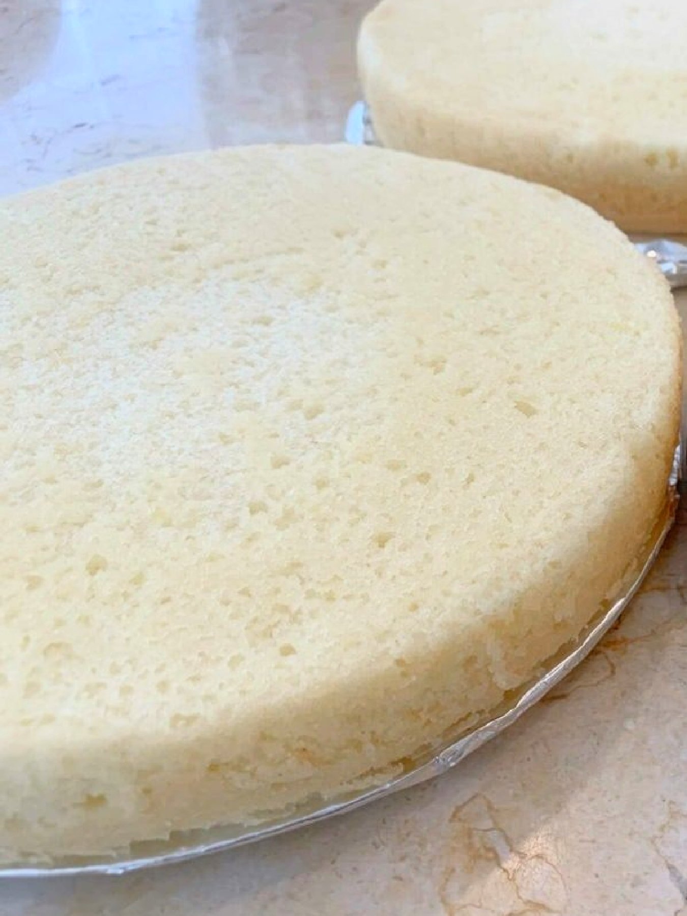 Two Lemon Cake Layers, each resting on foil-wrapped cake boards.