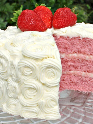 Sliced strawberry layer cake on pedestal