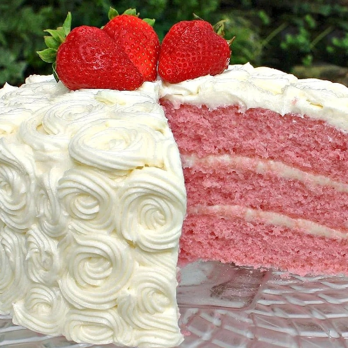 Sliced Strawberry Cake from Scratch, on a clear glass pedestal.