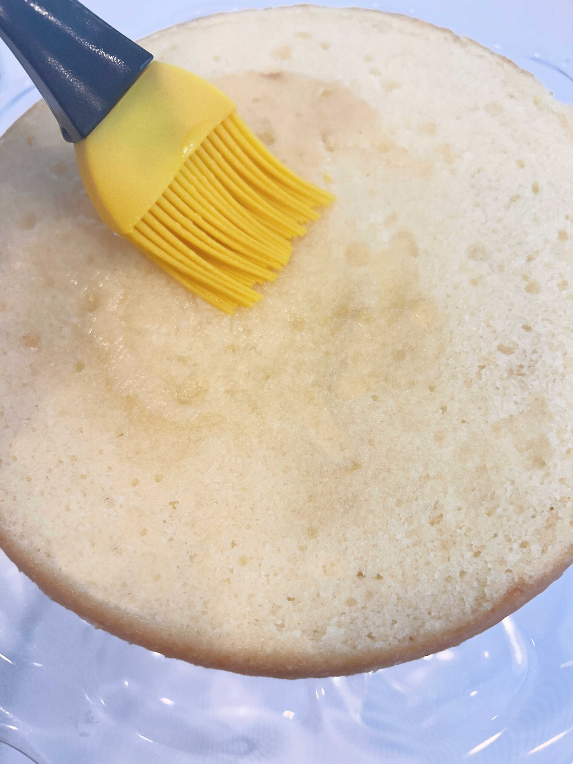 Brushing Rum Simple Syrup onto Pina Colada Cake layer.