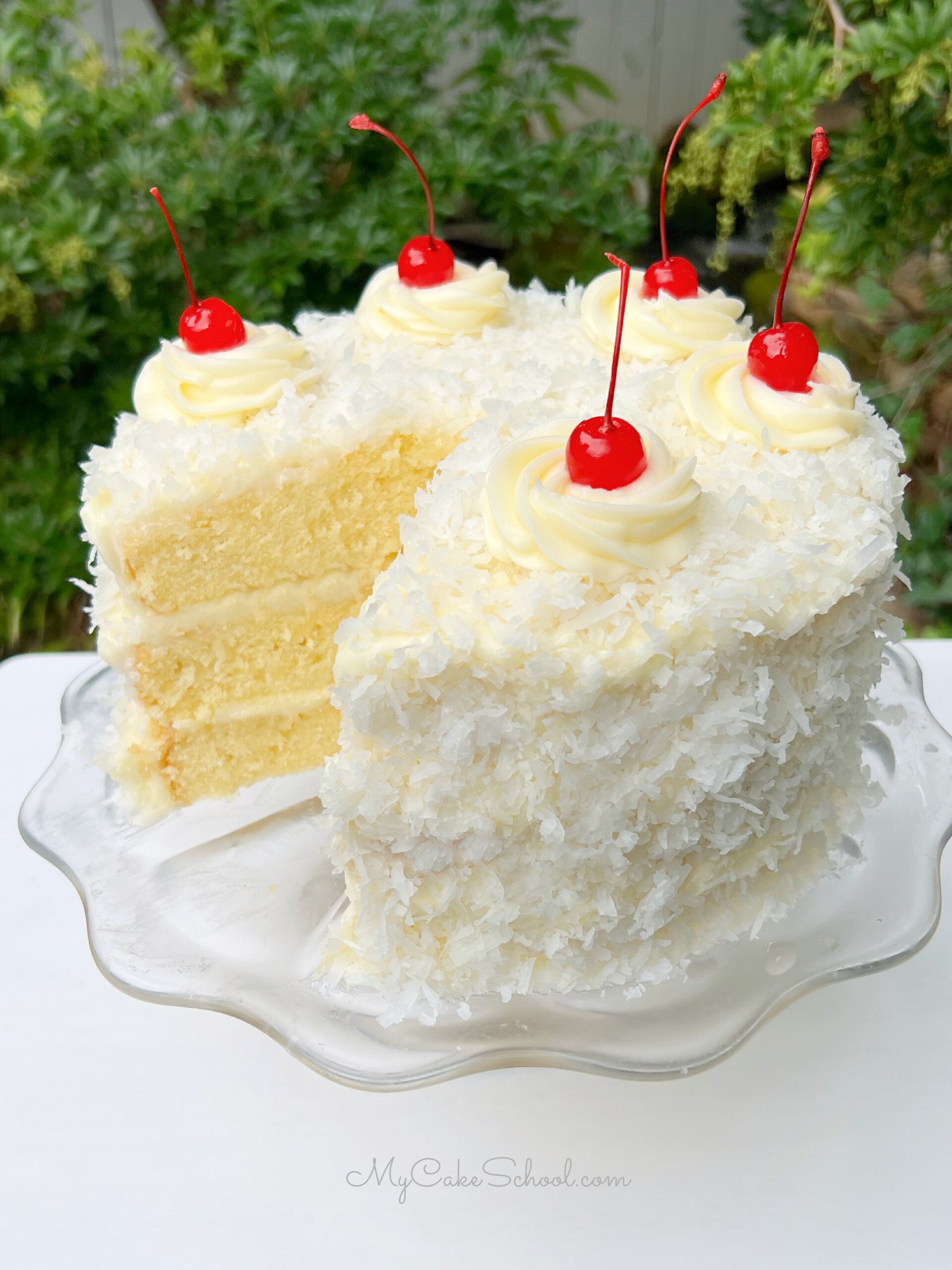 Pina Colada Cake, sliced, on a glass pedestal.