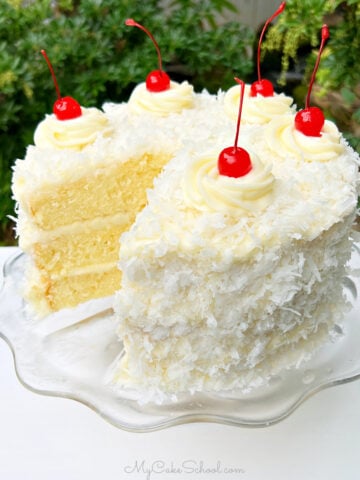 Sliced Pina Colada Cake on a glass pedestal.