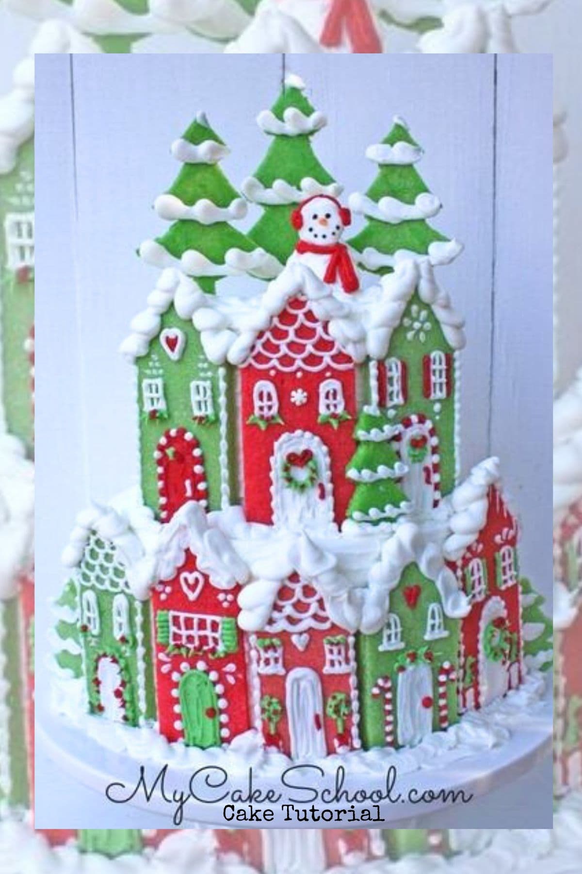 Christmas Village Cake on a pedestal, with red and green cookie houses across the front.