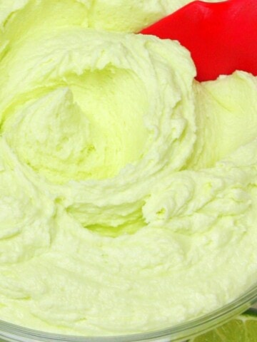 Tequila Lime Buttercream in a glass bowl with red spatula.