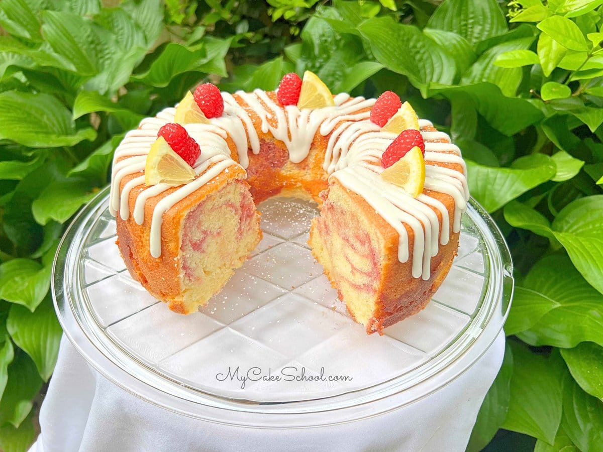 Lemon Raspberry Pound Cake, sliced, on a cake pedestal.