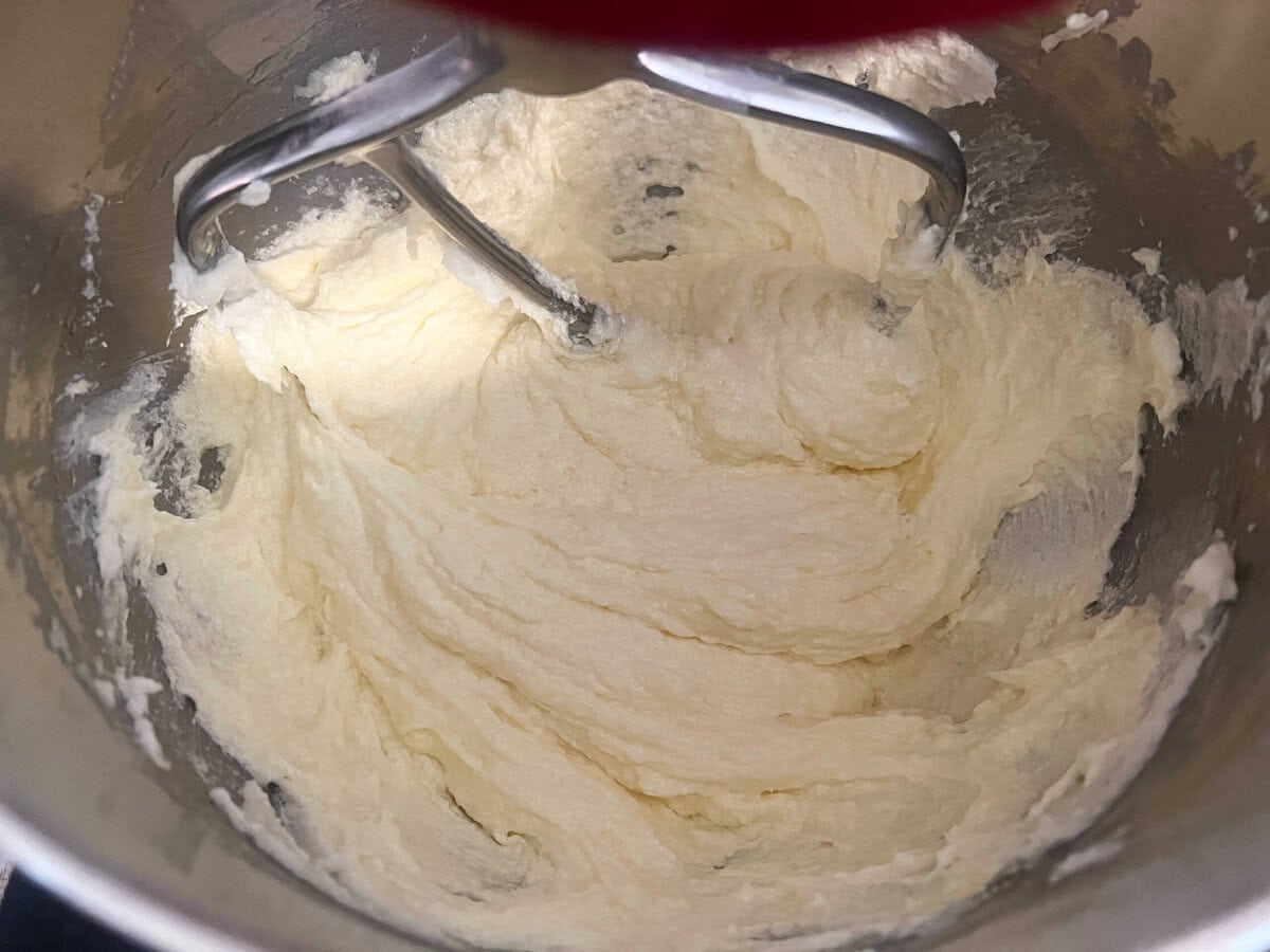 Mixing eggs into the butter and sugar mixture.