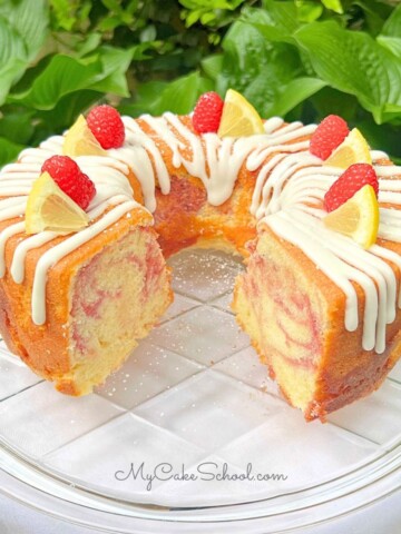 Lemon Raspberry Pound Cake, sliced, on a cake plate.