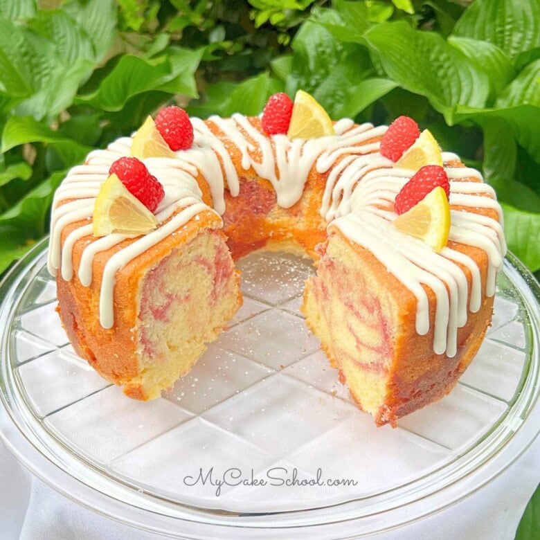 Lemon Raspberry Pound Cake, sliced, on a cake plate.
