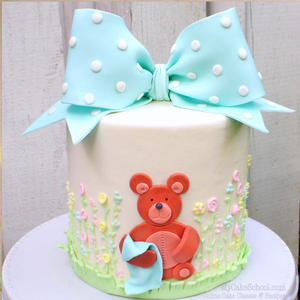 Cute teddy bear cake with gum paste bow and sweet piped buttercream flowers! 