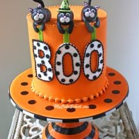 Orange cake topped with black cat cake toppers.