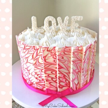 Pink and white marbled chocolate panel cake on a cake pedestal