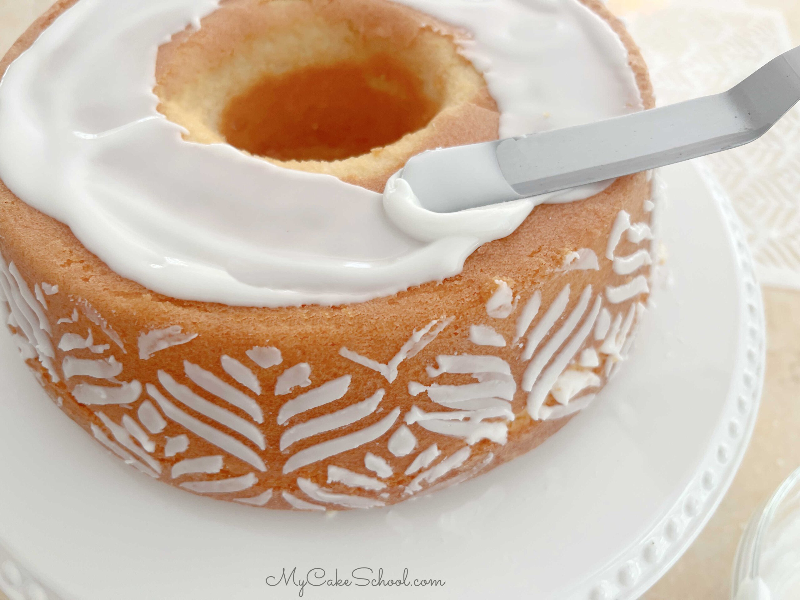 Spreading the top of the pound cake with sugar glaze.