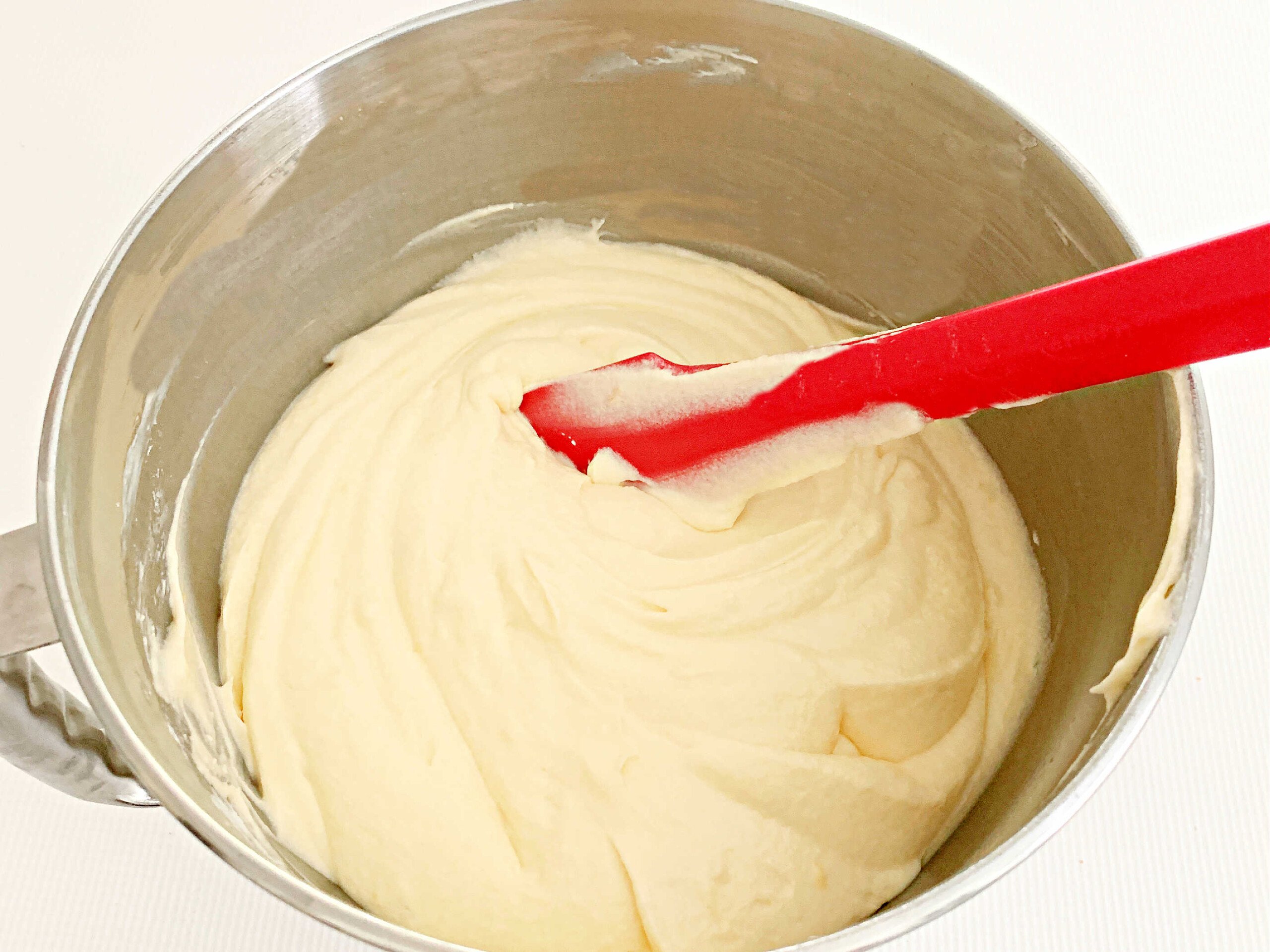 Lemon Pound Cake Batter in mixing bowl with red spatula.