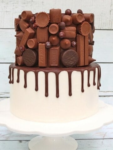 Candy Bar Drip Cake on White Pedestal