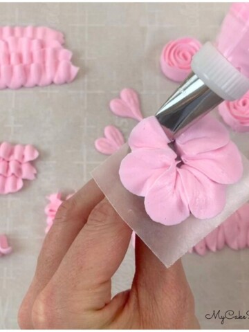 Piping a buttercream flower on a rose nail.