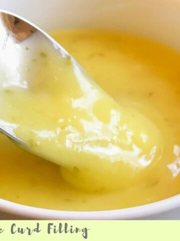 Easy and Delicious Lime Curd in a white bowl with a spoon.