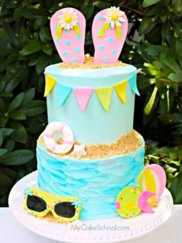 Tiered Beach Cake with flip flop cake topper on a cake pedestal.