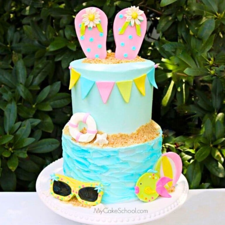 Tiered Beach Cake with flip flop cake topper on a cake pedestal.