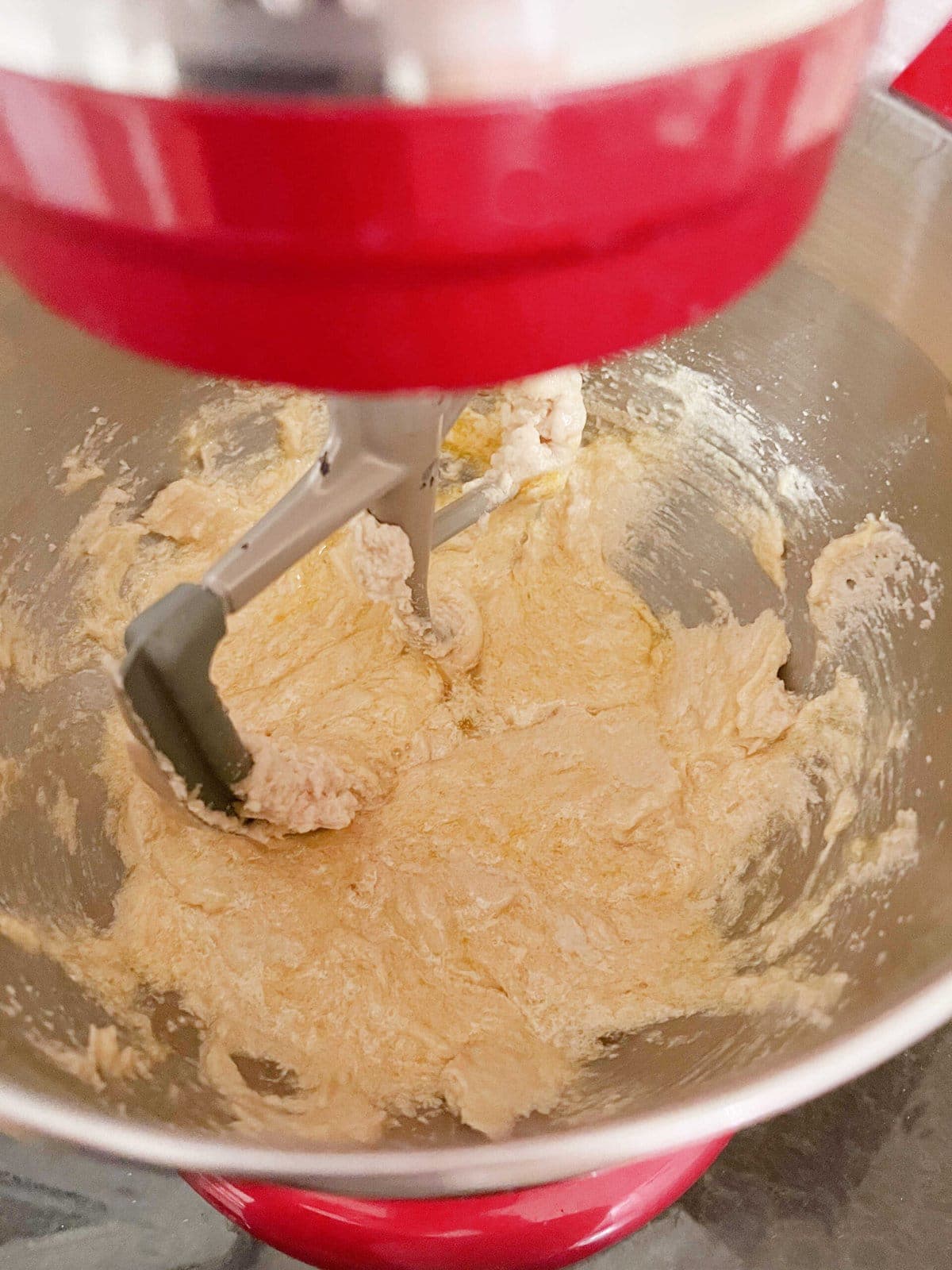 Adding eggs to the cake batter in mixing bowl.