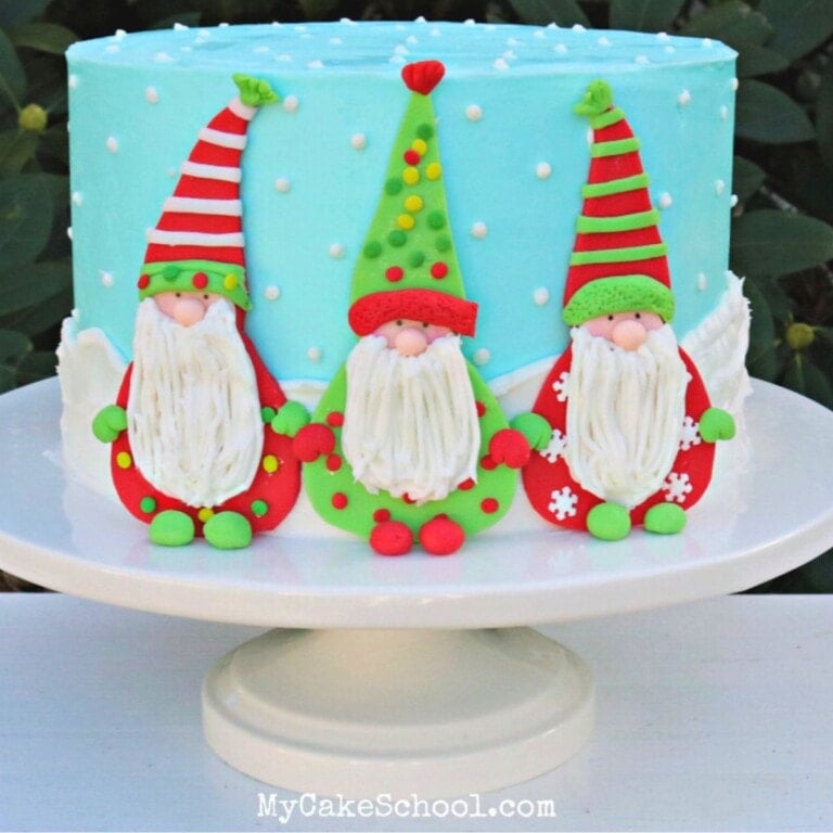 Gnome cake on a white pedestal.