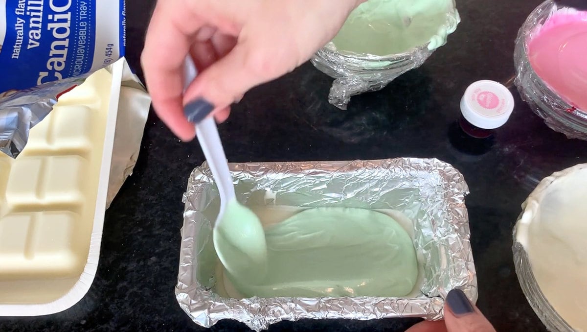 Layering melted green chocolate coating onto chilled white chocolate layer