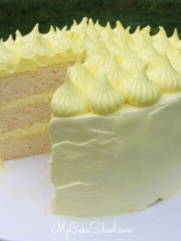 Lemon Sour Cream Cake, sliced, on a cake pedestal.