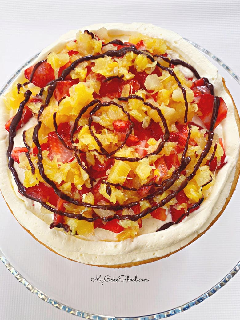 Banana Split Layer Cake recipe! This amazing cake has soft banana cake layers, and filling of strawberries, pineapple, and whipped cream! This Banana Split Layer Cake Recipe is so flavorful!