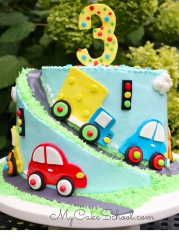 Cars and Trucks Cake on a white pedestal.Spiral Carved Cake.