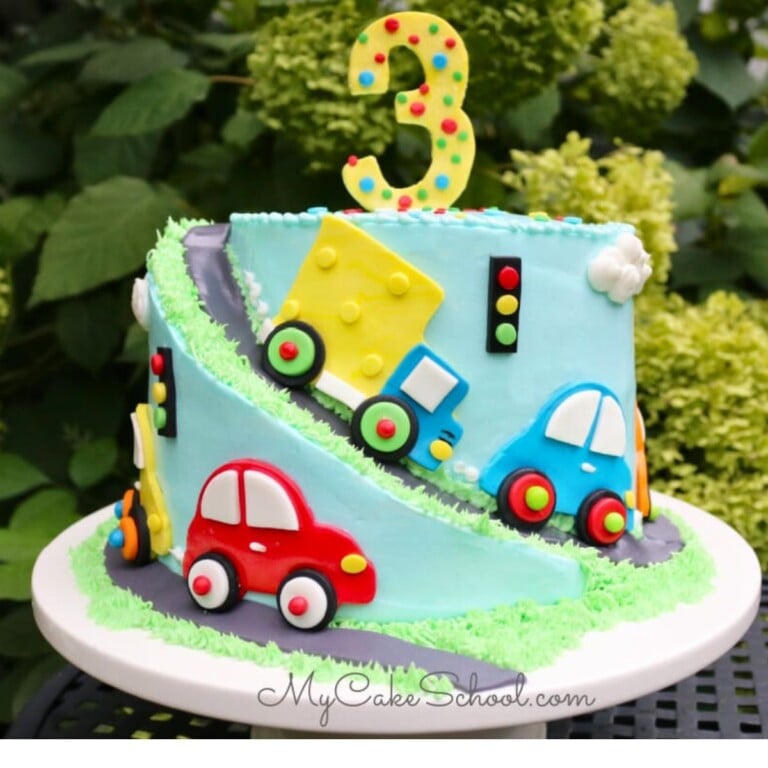 Cars and Trucks Cake on a white pedestal.Spiral Carved Cake.