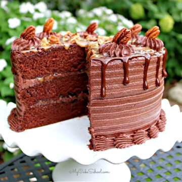 Sliced Chocolate Turtle Cake on white pedestal.