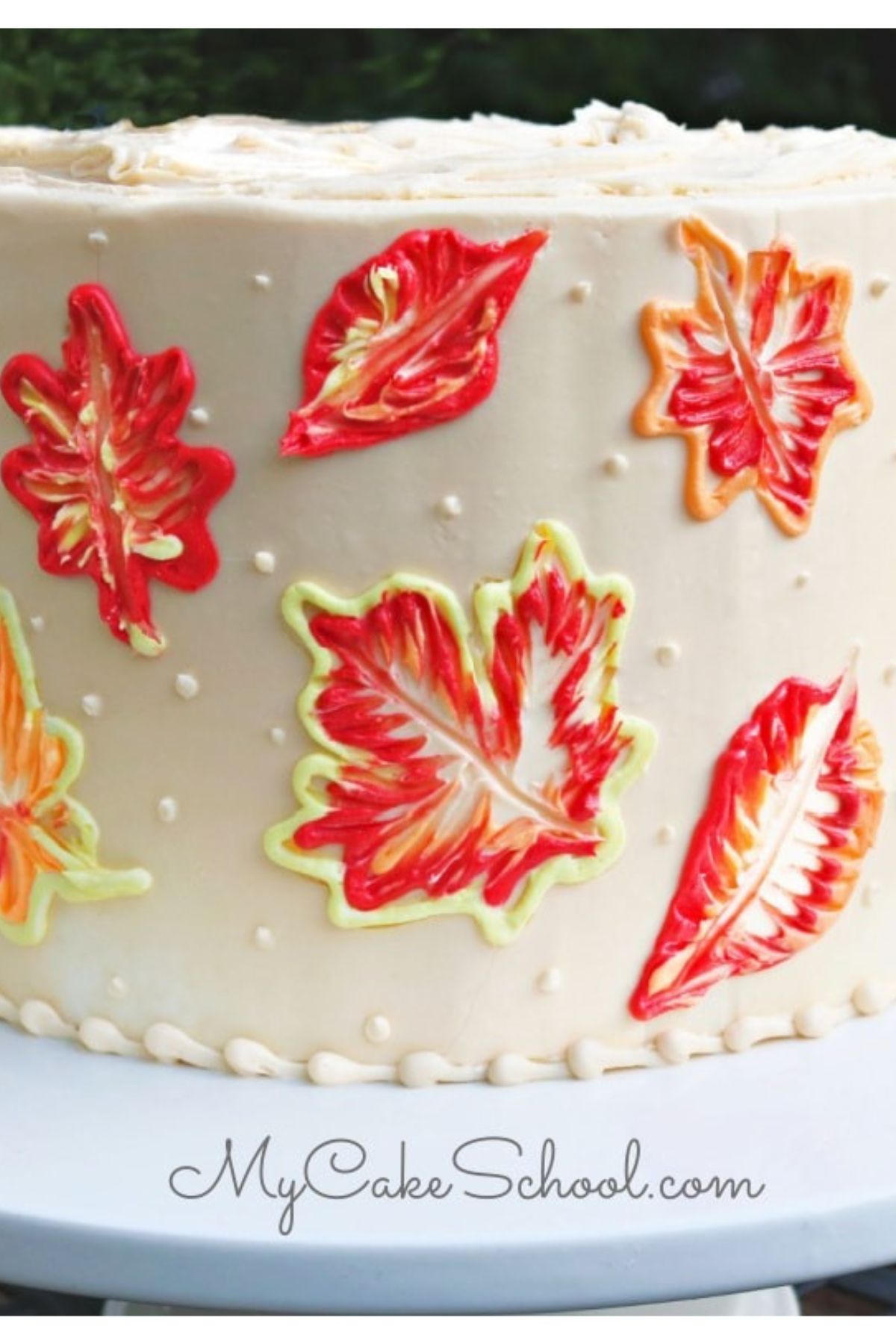 Closeup of finished Brush Embroidery Leaves cake, featuring brightly colored orange, yellow, and red leaves.