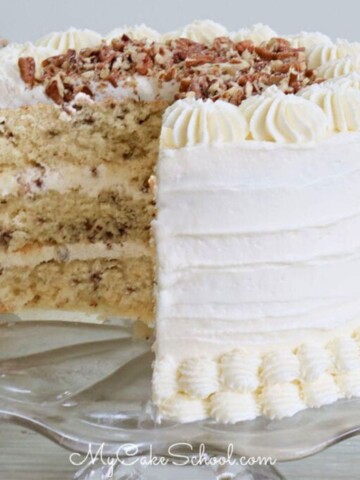 Sliced Butter Pecan Cake on glass pedestal.