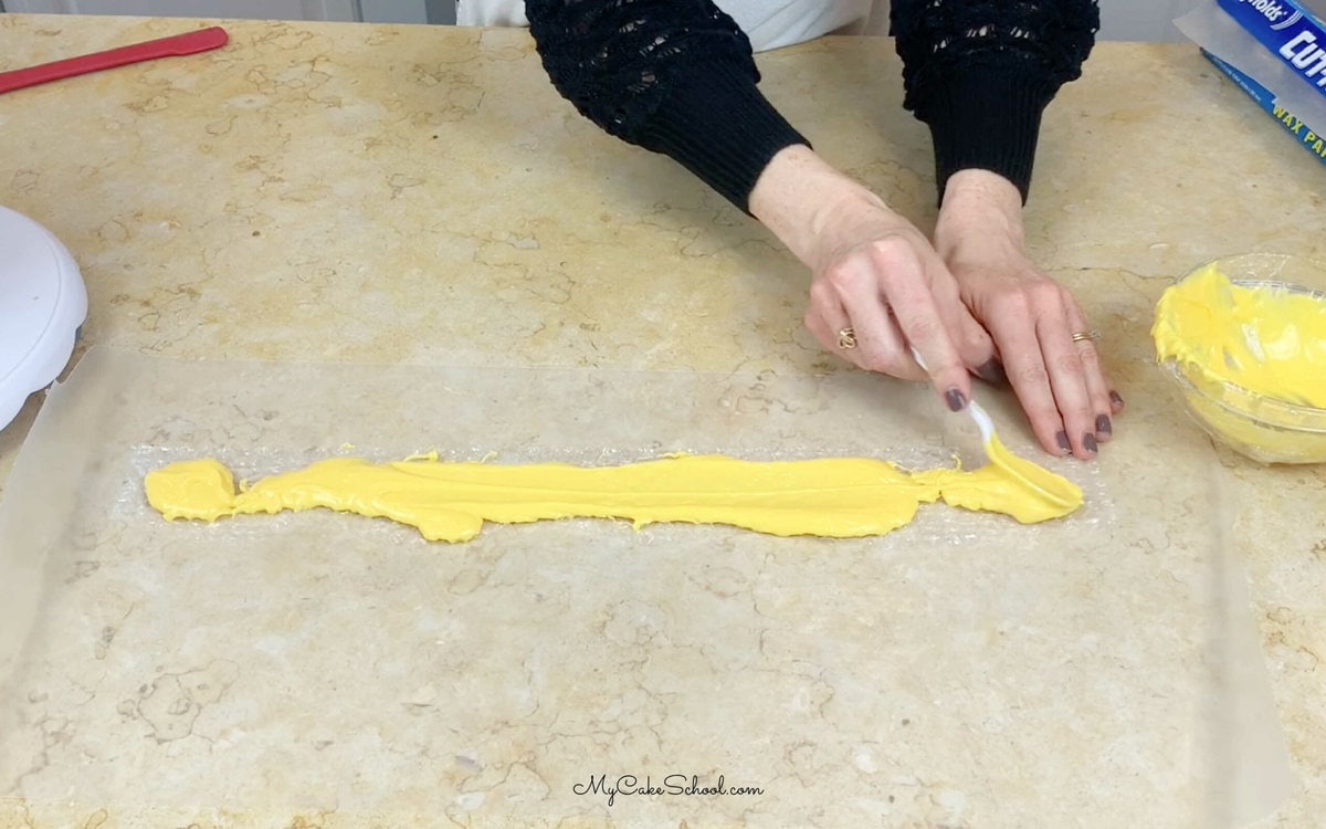 Spreading Melted Yellow Candy Coating over strip of bubble wrap