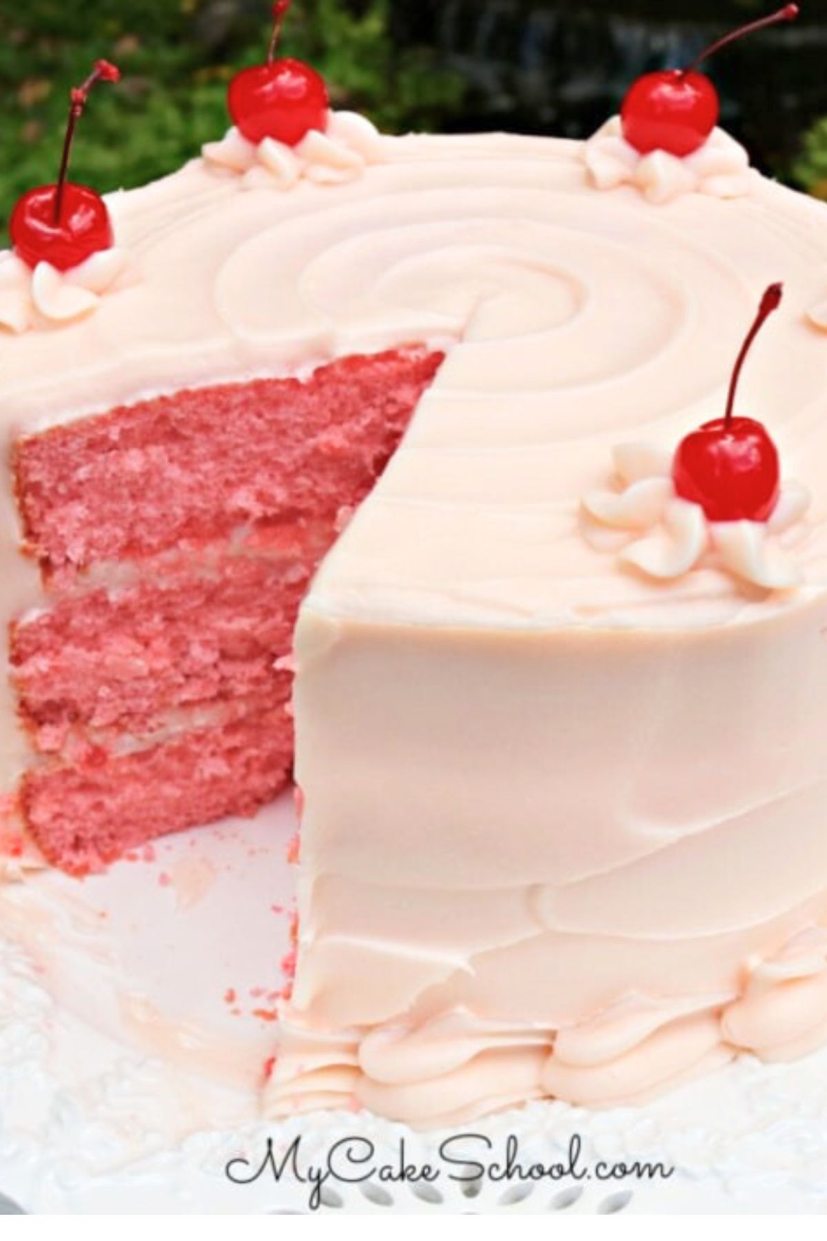 Cherry Cake from Cake Mix, sliced, on a white pedestal. Topped with maraschino cherries.