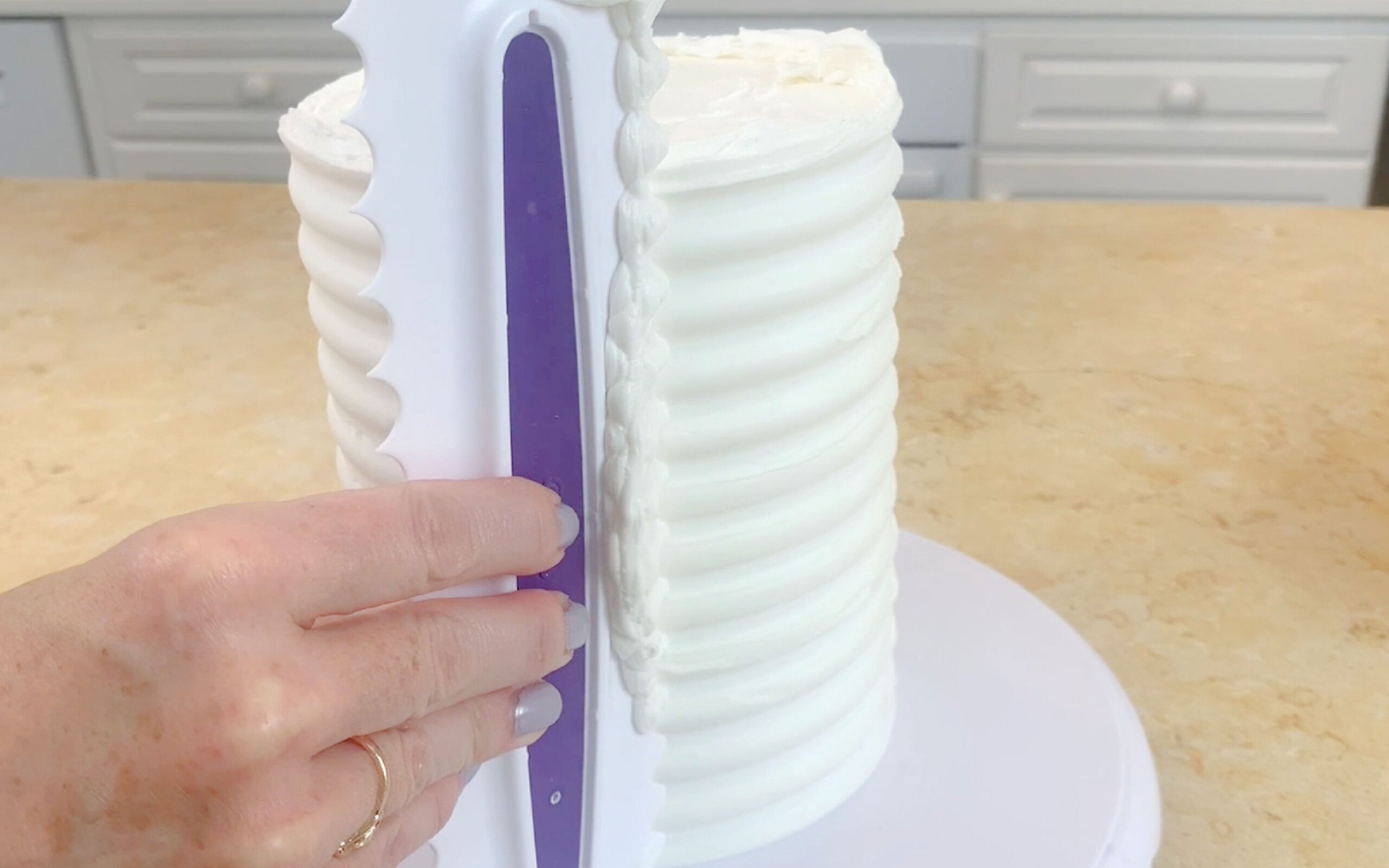 Combine white buttercream frosting around the sides of a cake.