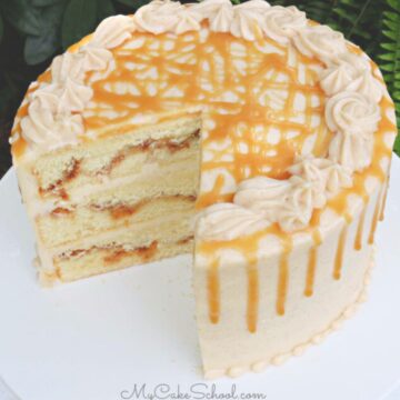 Sliced snickerdoodle cake on a white pedestal.