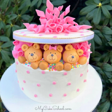 Teddy Bear Gift Cake with three fondant bears. Cake on white pedestal.