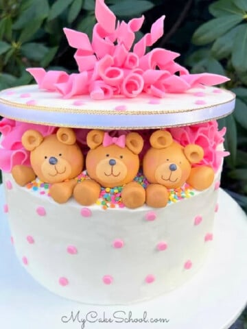 Teddy Bear Gift Cake with three fondant bears. Cake on white pedestal.