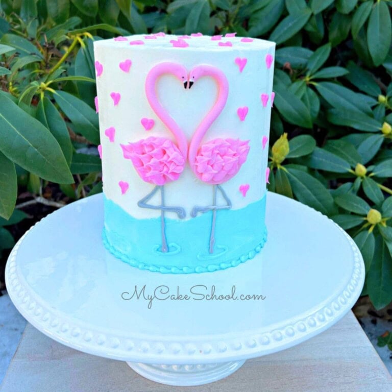 Sweetheart flamingos cake on a cake pedestal.