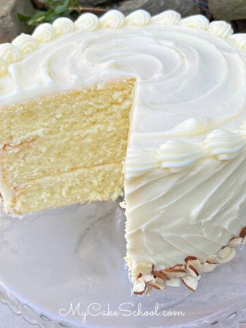 Moist Almond Cream Cake, sliced, on a pedestal